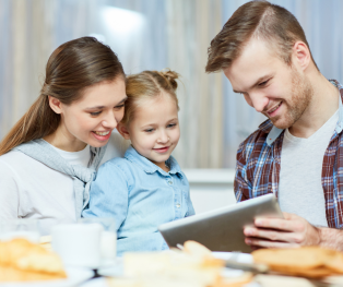 genitori che mostrano un tablet alla figlia